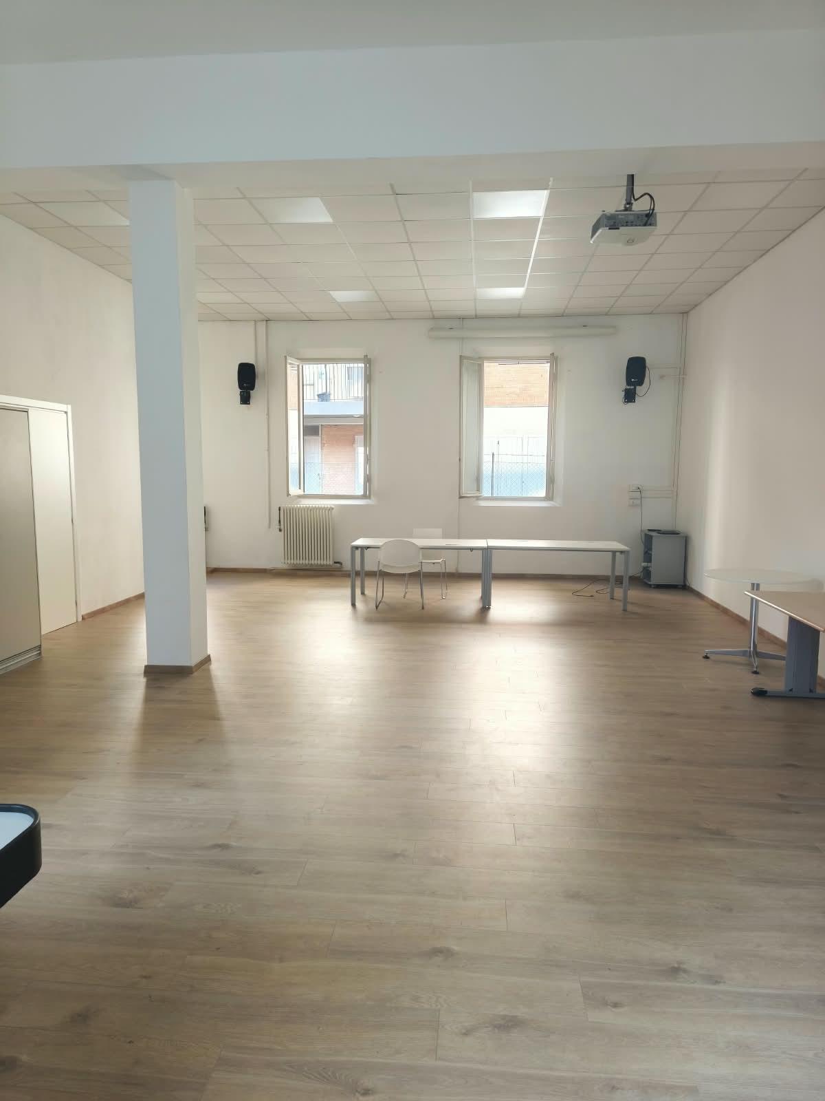 Sala Polivalente con tavoli bianchi e pavimento in legno